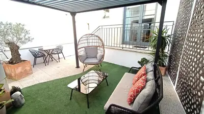 a patio with a couch and chairs on a balcony at Private Terrace at Flores Street in Porto