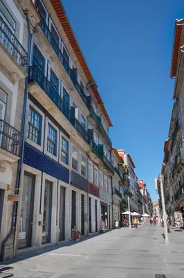 an empty street in a city with buildings at Private Terrace at Flores Street in Porto