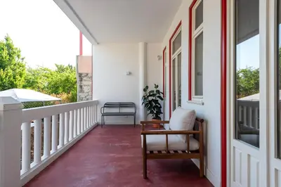 a porch with a chair and a window at Bonfim 241 Family House in Porto
