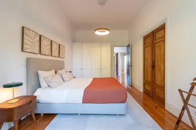 a bedroom with a large bed and a wooden table at Bonfim 241 Family House in Porto