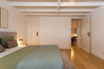 a bedroom with a large bed and a dining room at Bonfim 241 Family House in Porto