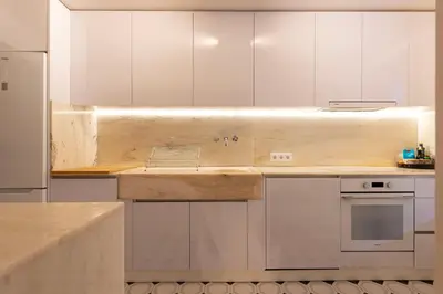 a white kitchen with white cabinets and a sink at Bonfim 241 Family House in Porto