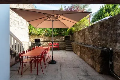 a table and chairs with an umbrella on a patio at Bonfim 241 Family House in Porto