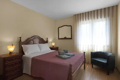a bedroom with a bed and a chair and a mirror at Vintage Copio Apartment in Vila Nova de Gaia