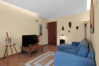 a living room with a blue couch and a tv at Vintage Copio Apartment in Vila Nova de Gaia