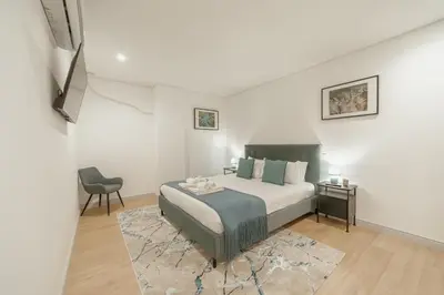 a bedroom with a bed and a chair at Downtown Gold Bolhao by Vacationy in Porto