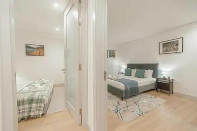 a white bedroom with a bed and a window at Downtown Gold Bolhao by Vacationy in Porto