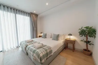 a bedroom with a large bed and a potted plant at Downtown Gold Bolhao by Vacationy in Porto