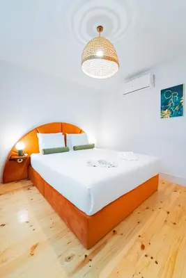 a bedroom with a large bed with a wooden floor at Lifestyle at Porto by Upperground in Porto