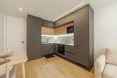 a kitchen with gray cabinets and a white couch at Downtown Premium With Balcony by Vacationy in Porto