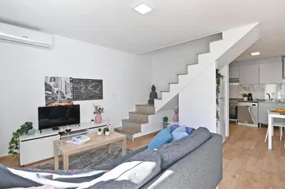 a living room with a couch and a staircase at The Porto Way in Porto