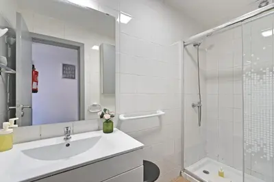 a white bathroom with a sink and a shower at The Porto Way in Porto