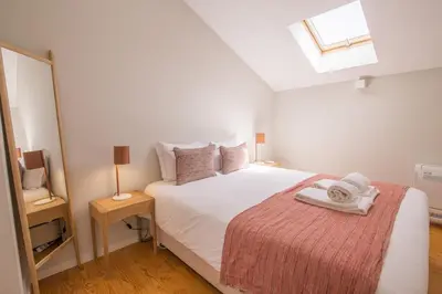 a bedroom with a white bed and a window at Almada 151 - 3T in Porto