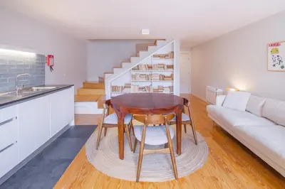 a kitchen and living room with a table and a couch at Almada 151 - 3T in Porto