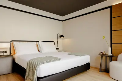 a bedroom with a white bed and a chair at Porto River Soul Hotel in Vila Nova de Gaia