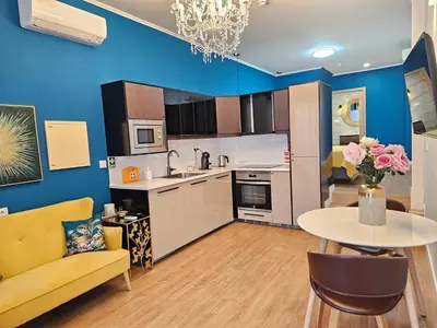 a kitchen and living room with a table and a yellow couch at Serendipity in Porto