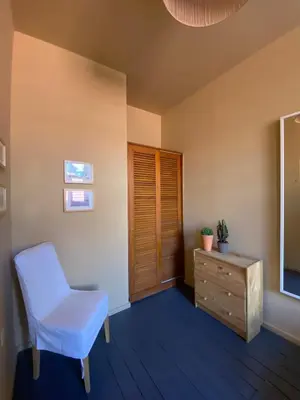 a room with a chair and a dresser and a television at Sunny Apartment in Porto