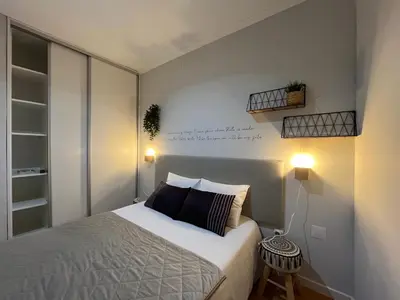 a bedroom with a bed and two lights on the wall at Typical Oporto House in Porto