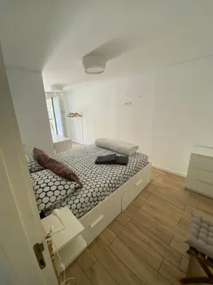 a bed in a white room with a bed frame at Apartamento Formosa in Porto