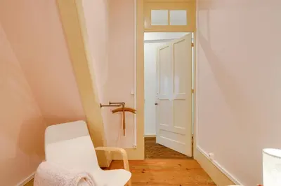 a room with a white chair and a door at Cedofeita Vintage House DA'Home in Porto
