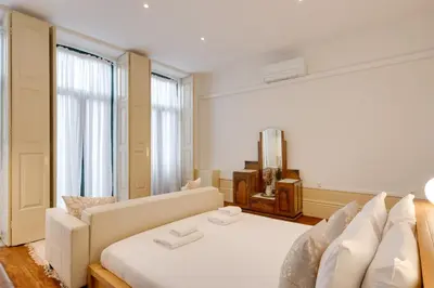 a room with a bed and a couch and a television at Cedofeita Vintage House DA'Home in Porto