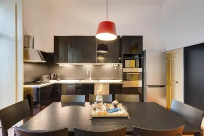 a kitchen with a table with chairs and a dining room at Cedofeita Vintage House DA'Home in Porto