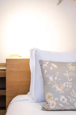 a bed with a pillow with a flower pattern on it at Cedofeita Vintage House DA'Home in Porto