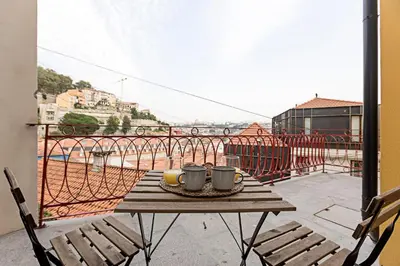 a table on a balcony with two mugs on it at Superb Flat w Balcony and AC by LovelyStay in Porto