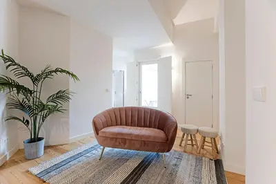 a living room with a brown chair and a plant at Superb Flat w Balcony and AC by LovelyStay in Porto