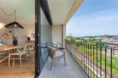 a room with a balcony with a table and chairs at Scenic River-View T1 by Lisbeyond in Vila Nova de Gaia
