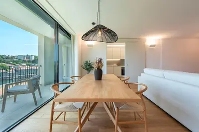 a dining room with a table and a couch at Scenic River-View T1 by Lisbeyond in Vila Nova de Gaia