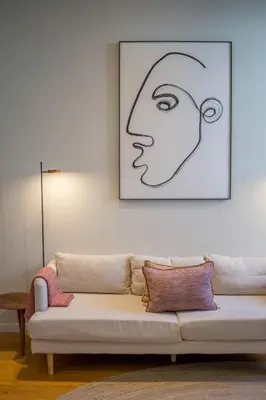 a couch in a living room with a picture of a woman at Almada 151 - 1T in Porto