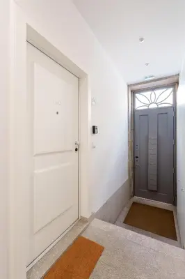 an empty hallway with a door and a window at VIVA João IV Residence Studios in Porto
