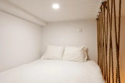 a bed with white sheets and pillows in a room at VIVA João IV Residence Studios in Porto