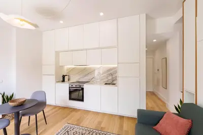 a living room with white walls and a table and chairs at VIVA João IV Residence Studios in Porto