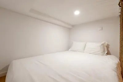 a bedroom with a white bed with white sheets and pillows at VIVA João IV Residence Studios in Porto