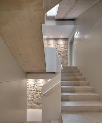 a staircase in a house with a stone wall at Republica 144 Apartamentos by DA'Home in Porto