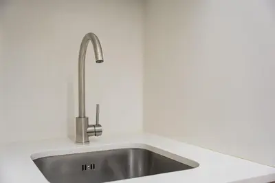 a stainless steel kitchen sink in a white kitchen at GuestReady - Vereda Downtown Apartments in Porto