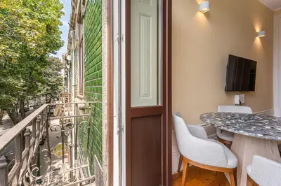 a room with a balcony with a table and chairs at GuestReady - Vereda Downtown Apartments in Porto