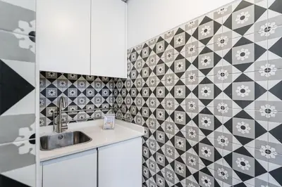 a kitchen with a sink and a tiled wall at GuestReady - Vereda Downtown Apartments in Porto