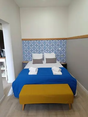 a bedroom with a blue and yellow bed with towels on it at Porto Alma 388 - Silent city center in Porto
