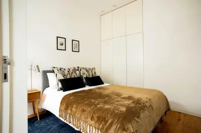 a bedroom with a large bed with white walls at PortoCenter METRO Marquis Cozy apartment in Porto