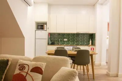 a kitchen with a table and chairs and a kitchen with a table and a kitchen at T2 Pedra do Bonfim, Centro do Porto com Pátio e Churrasqueira in Porto