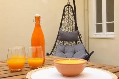 a table with a bowl of orange juice and two glasses at T2 Pedra do Bonfim, Centro do Porto com Pátio e Churrasqueira in Porto