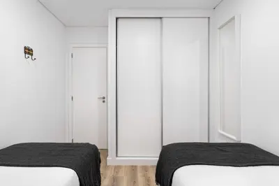 two beds in a room with white walls at GuestReady - Fantastic Porto Flat in Porto