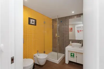 a bathroom with a shower and a toilet and a sink at Rosario Duplex in Porto
