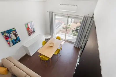 a dining room with a table and a couch at Rosario Duplex in Porto