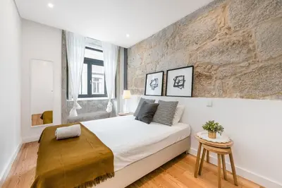 a bedroom with a white bed and a brick wall at Modern Invicta by Upperground in Porto