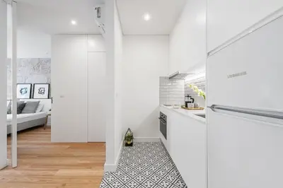 a white kitchen with white cabinets and a floor at Modern Invicta by Upperground in Porto