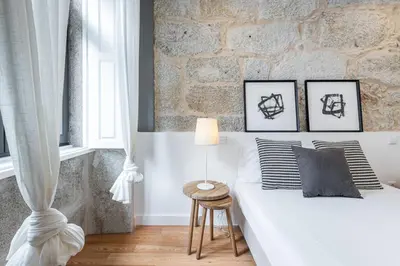 a bedroom with a white bed and a brick wall at Modern Invicta by Upperground in Porto